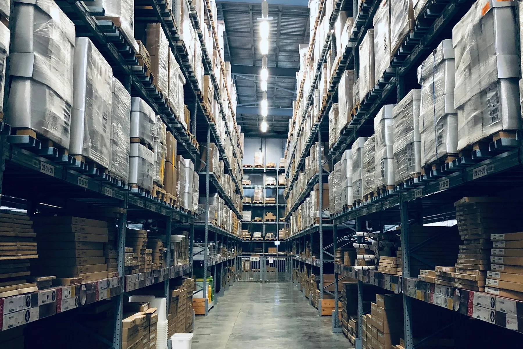 Pallet racking in a working warehouse, with boxed goods stored on industrial shelves